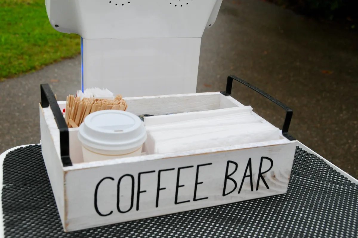 Man sieht eine Holzbox, die zur Kaffeebar ausgestattet wurde.